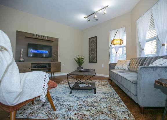 A living room with a couch, chair, and television.