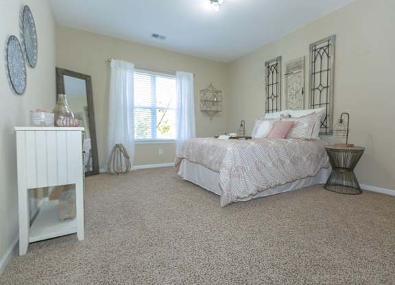 A bedroom with a large bed and a dresser.