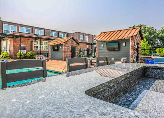 A backyard with a pool and a small building.