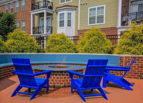 Three blue chairs are placed around a table on a patio.