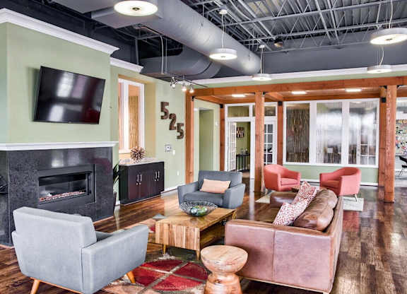 A living room with a grey couch, a wooden coffee table, and a fireplace.