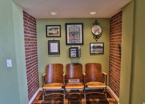 Three brown chairs are lined up in a waiting area.