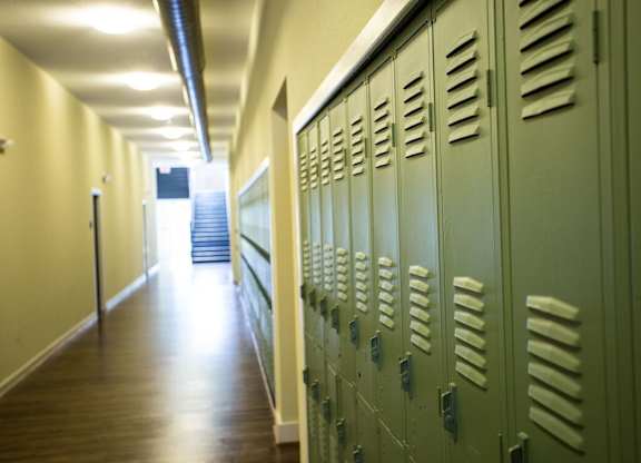 A long hallway with green lockers on the side.