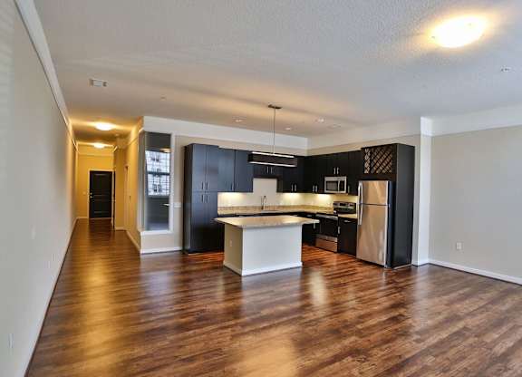 A spacious kitchen with dark wood cabinets and a white island.