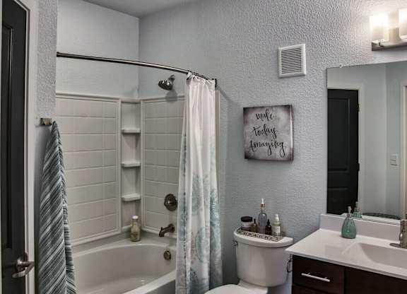 A bathroom with a white tub, toilet, and sink.