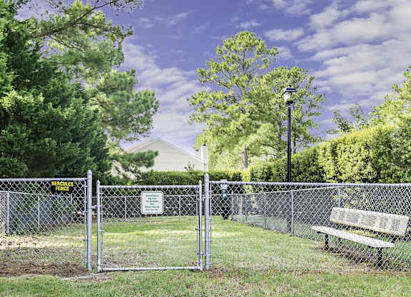 A park with a fence and bench.