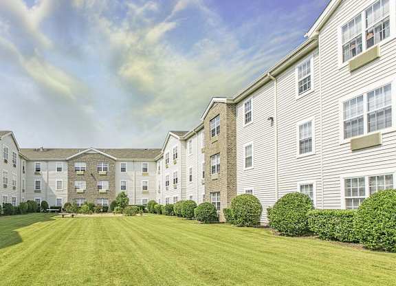 A large grassy area in front of apartment buildings.