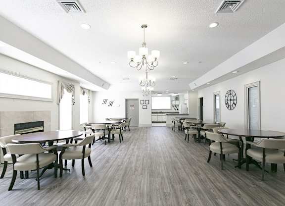 A large dining room with a fireplace and a chandelier.