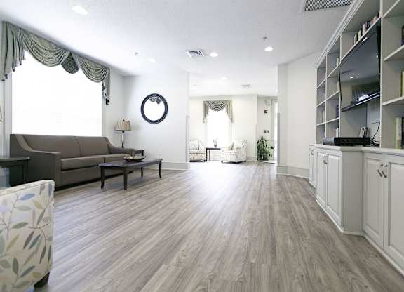 A living room with a brown couch and a wooden floor.