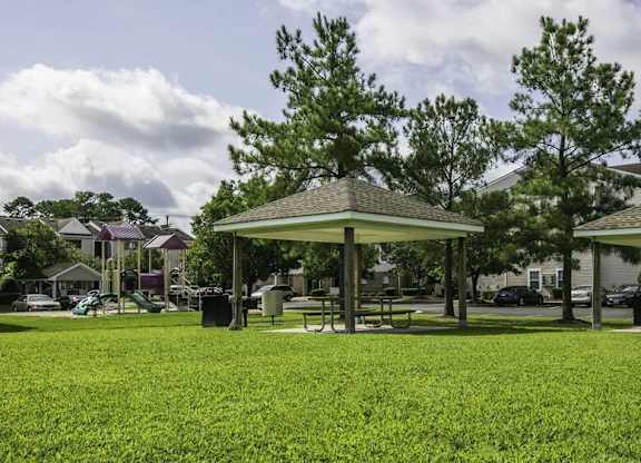 A gazebo is surrounded by a grassy field.