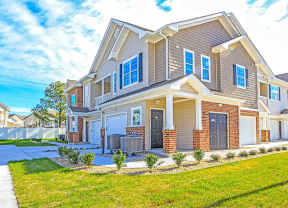 A large, well-maintained house with a driveway and landscaping.
