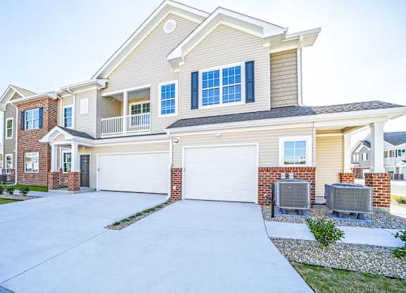 A large, two-story house with a garage and a driveway.