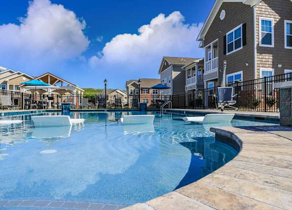 A swimming pool surrounded by a fence and buildings.