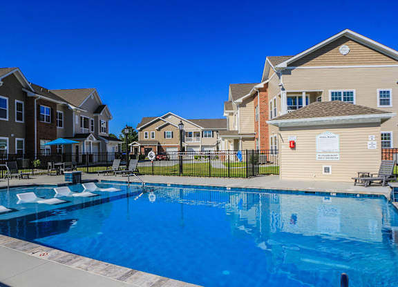 A swimming pool in front of apartment buildings.