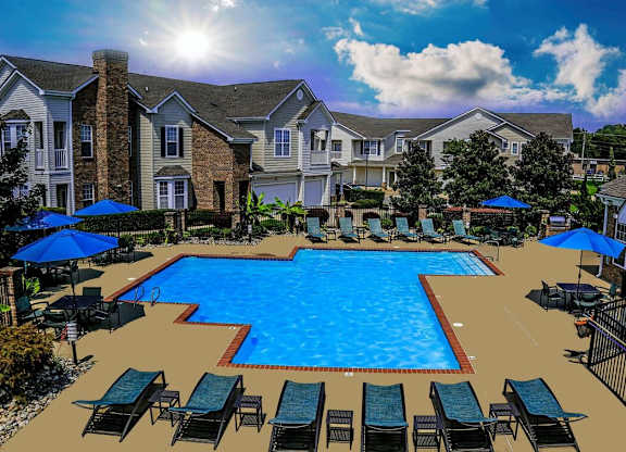 A large swimming pool surrounded by lounge chairs and umbrellas in front of a residential building.