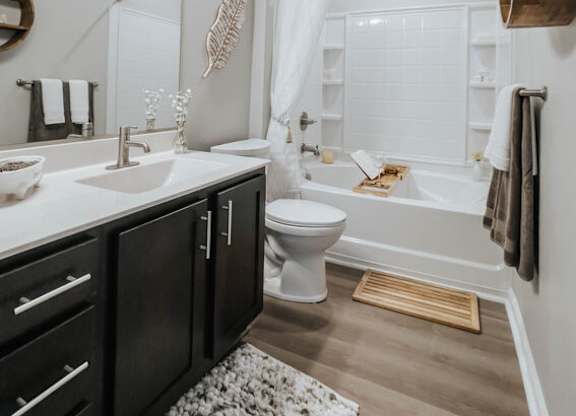 A bathroom with a white toilet, a sink, and a bathtub.