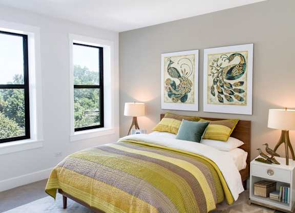 A bedroom with a large bed and two lamps.