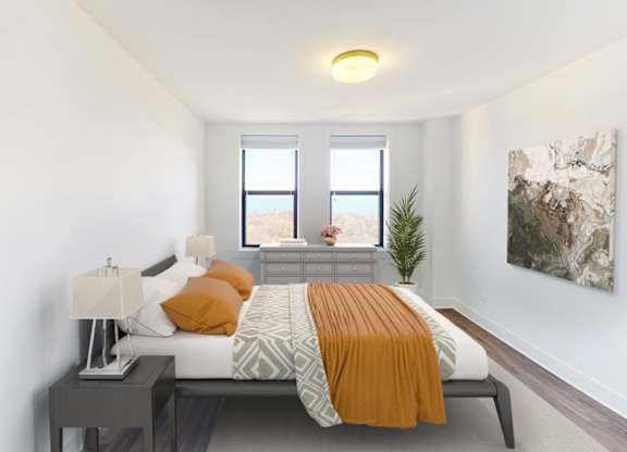 A bedroom with a bed, nightstand, and a plant.