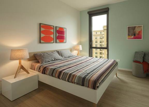 A bedroom with a bed, nightstand, and two lamps.