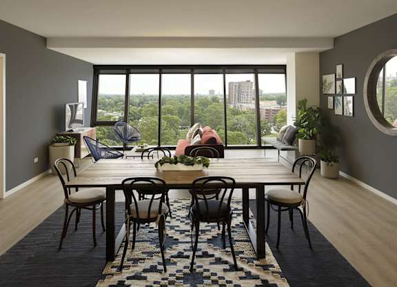 A dining room with a table set for six with a view of the city.