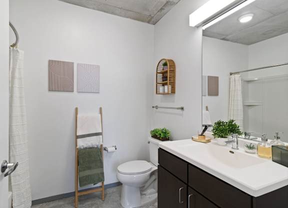 A bathroom with a toilet, sink, and mirror.