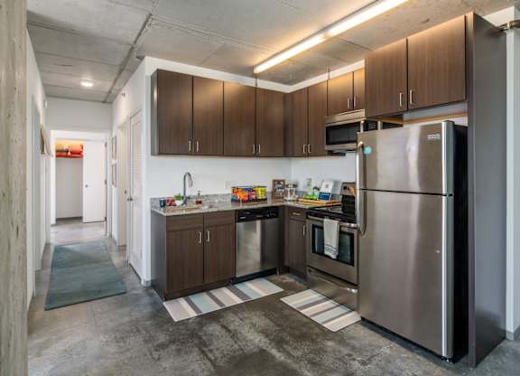A kitchen with a refrigerator on the right side.