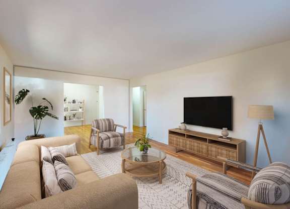 A living room with a large couch, a chair, a coffee table, and a television.