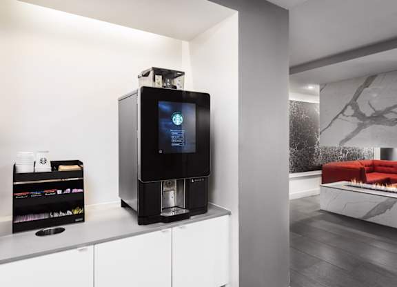A modern kitchen with a black coffee machine on the counter.