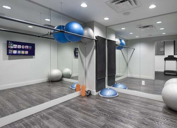 A room with exercise balls and a mirror on the wall.