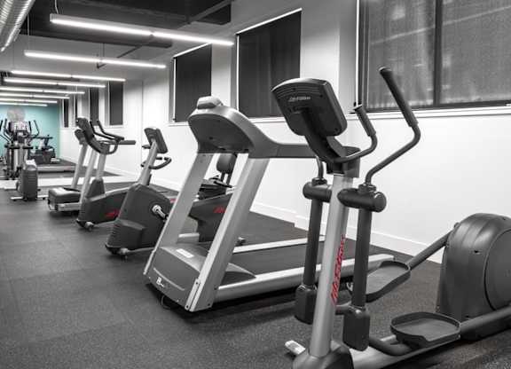A gym with treadmills and elliptical machines.