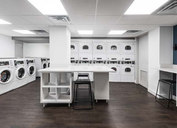 A laundry room with washing machines and a counter.