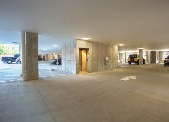 A parking garage with a concrete floor and pillars.