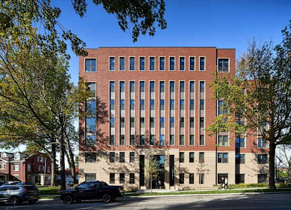 A large red brick building with a row of windows on the top floor.