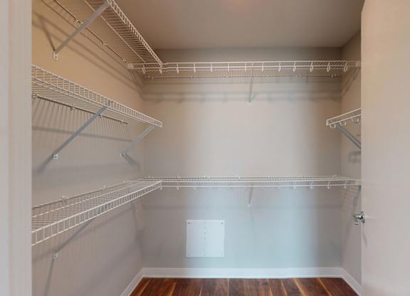 Empty walk-in closet with shelves and a door.