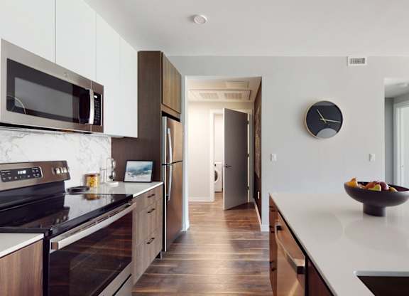 A modern kitchen with a bowl of fruit on the counter.