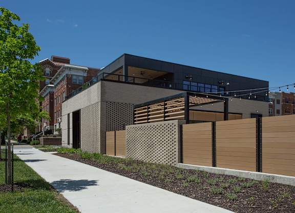 A modern building with a black facade and wooden fence.