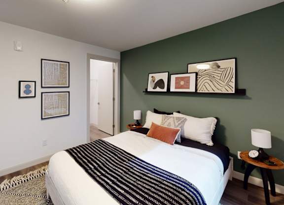 A bedroom with a large bed and a green wall.
