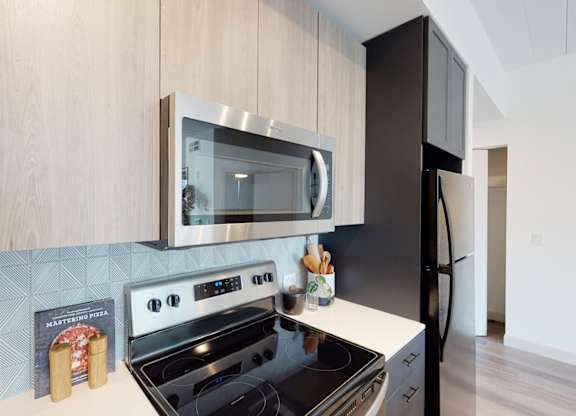 A modern kitchen with a black stove top oven and a black refrigerator.