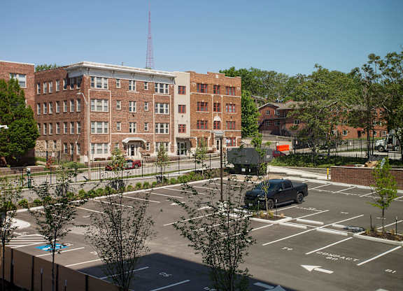 A parking lot with a building and a truck in the background.
