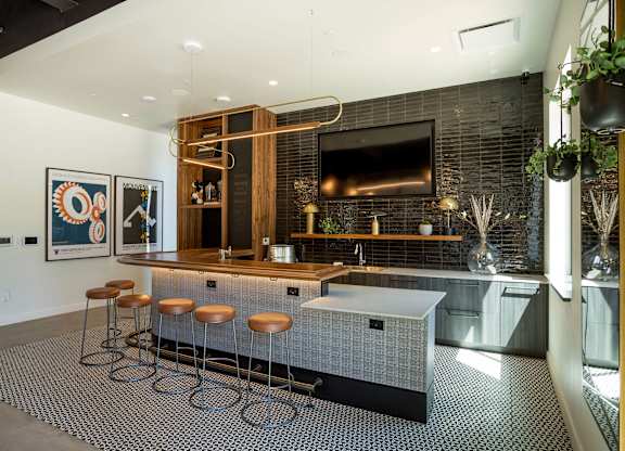 A modern kitchen with a bar area and stools.