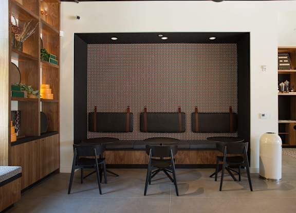 A room with a brown patterned screen and black chairs.