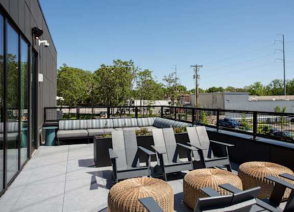 A patio with grey chairs and tables.