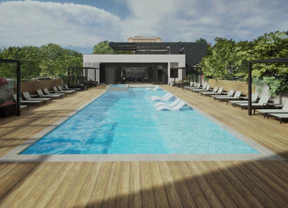 A large swimming pool with a wooden deck and lounge chairs.