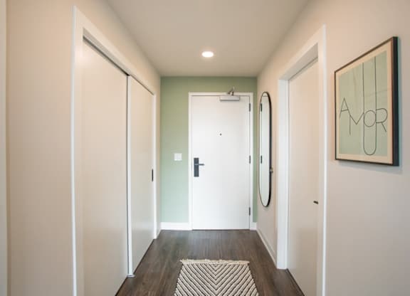 A hallway with a green door and a framed picture on the wall.