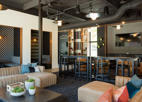 A modern living room with a sofa, coffee table, and a bar area.