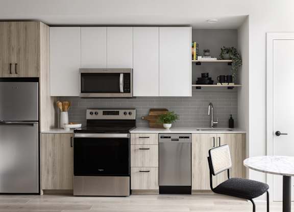 A modern kitchen with a refrigerator, oven, and microwave.