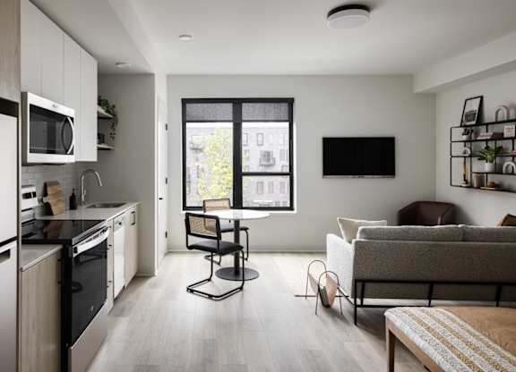 A modern kitchen with a dining area and a couch.