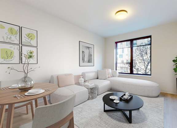 A living room with a grey sofa, a wooden table, and a black coffee table.