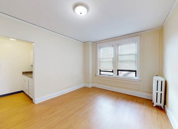 A room with a window and a radiator on the wall.