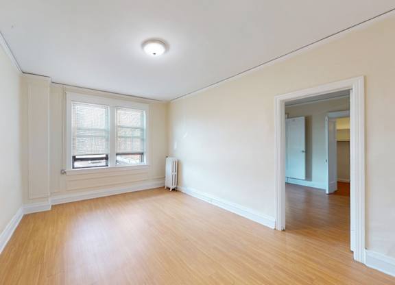 A room with a window and a radiator on the wall.
